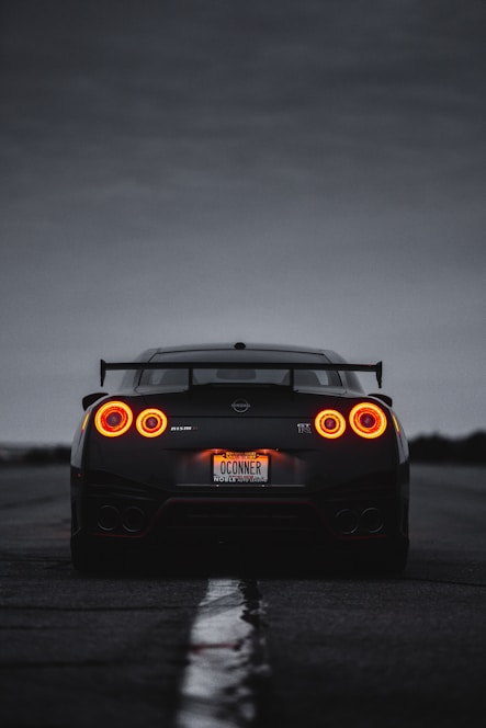 a black sports car with its lights on
