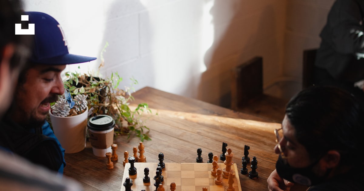 Foto zum Thema Eine Gruppe von Leuten, die eine Partie Schach spielen