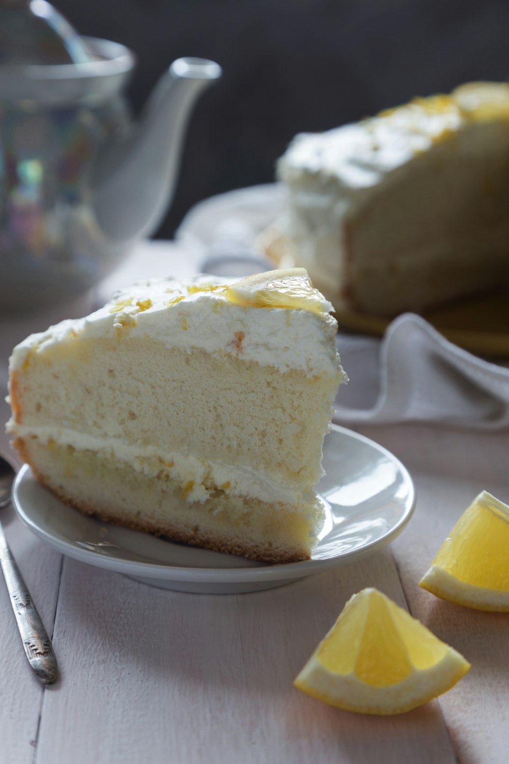 a slice of cake on a plate with lemon wedges