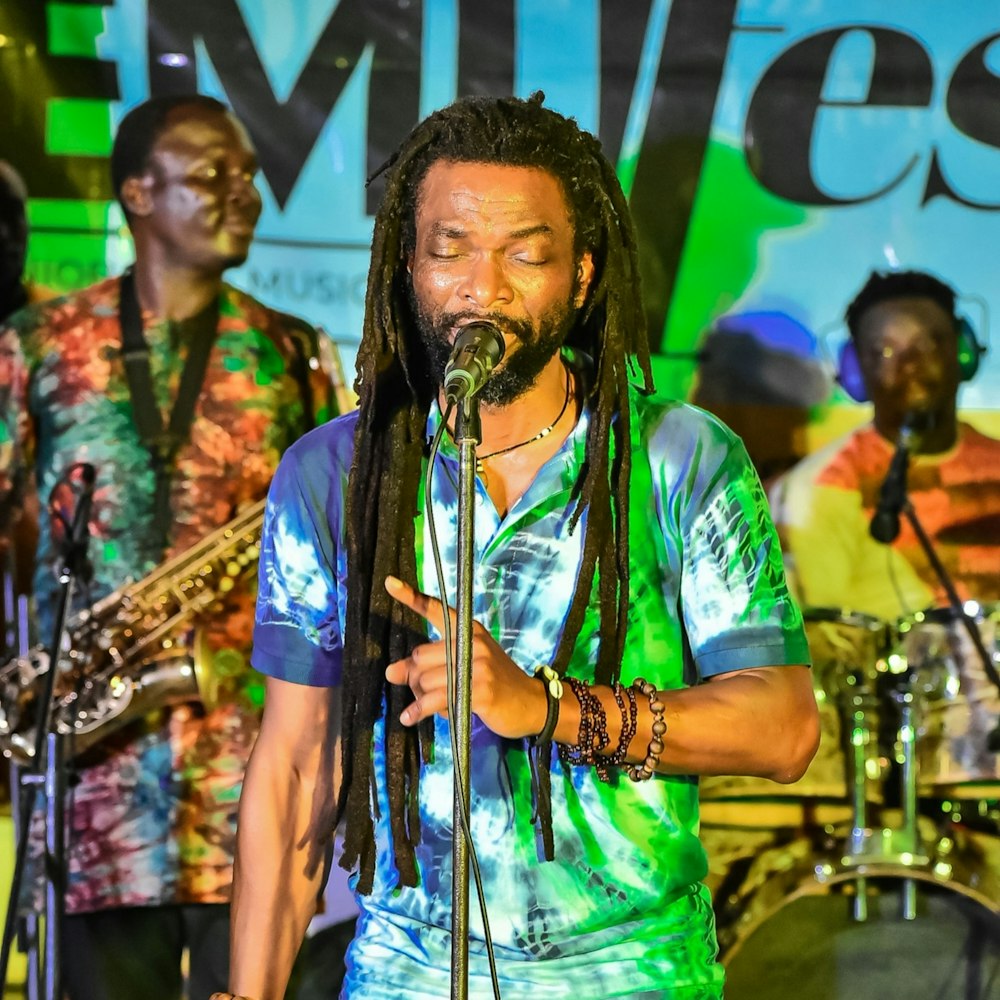 a man with dreadlocks singing into a microphone