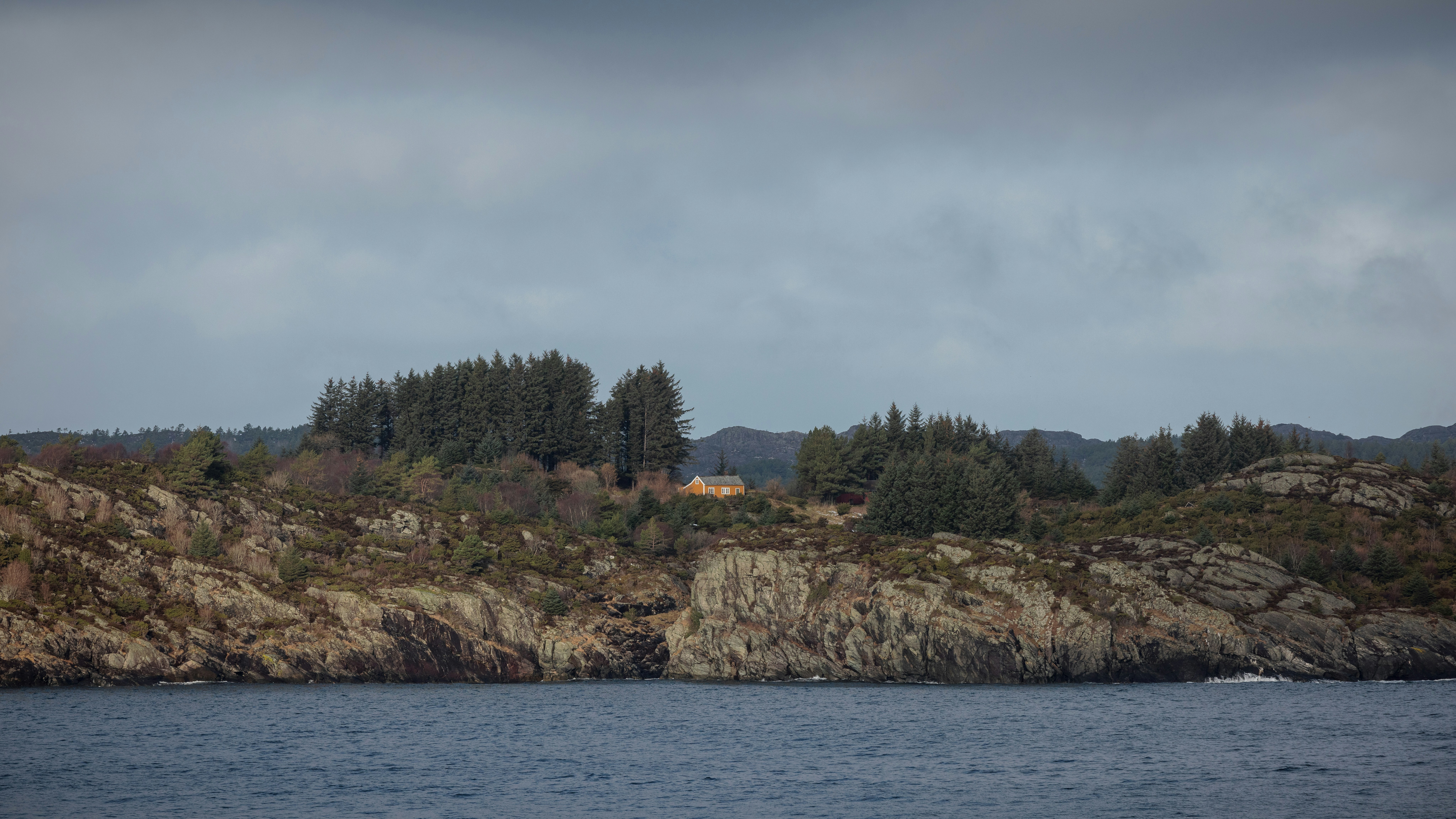 a house on a rocky island in the middle of the ocean