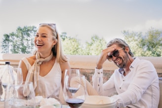 a man and a woman sitting at a table with wine glasses