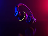 Close-up of futuristic headphones with neon purple and blue lighting accents.
