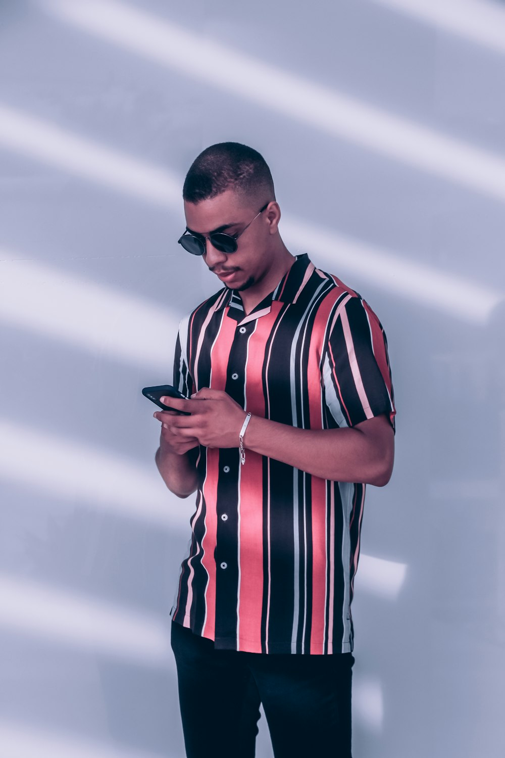 a man in a striped shirt using a cell phone