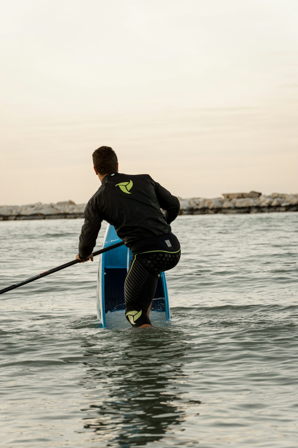 a man riding a paddle board on top of a body of water