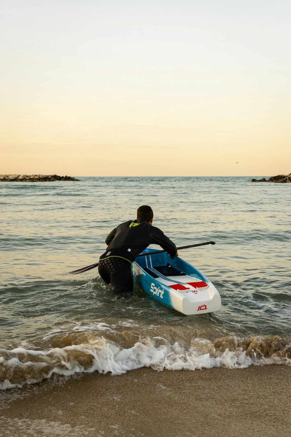 a man riding on top of a surfboard in the ocean