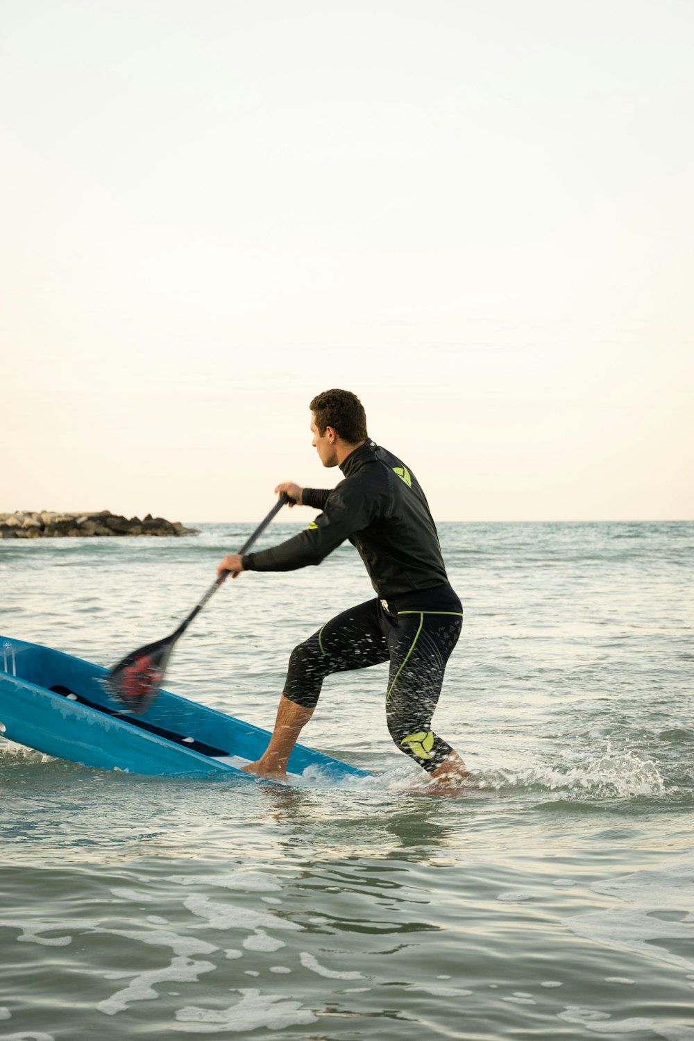 a man riding a paddle board on top of a body of water