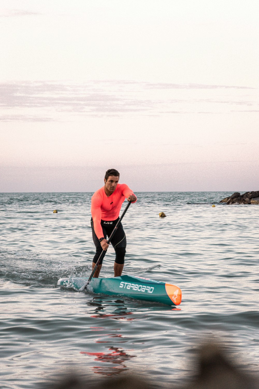 a man on a paddle board in the water