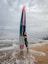 a man holding a surfboard on top of a sandy beach
