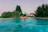 Couple relaxing by the swimming pool surrounded by lush greenery at aamby valley lonavala