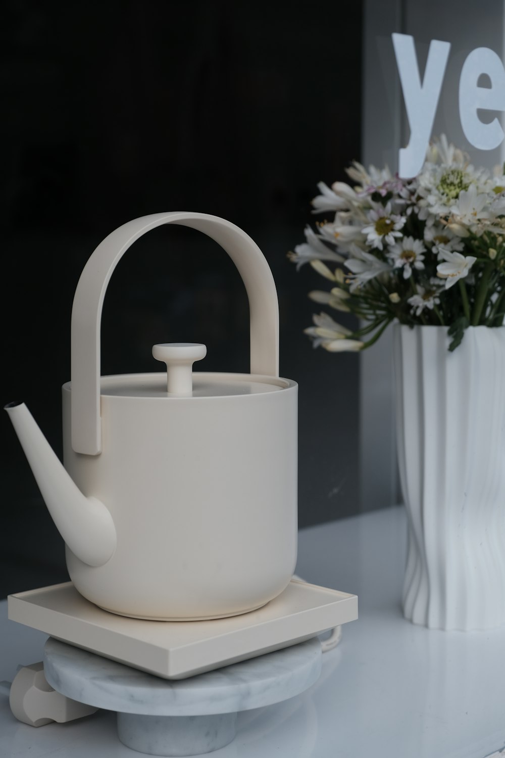 a white tea pot sitting on top of a white plate
