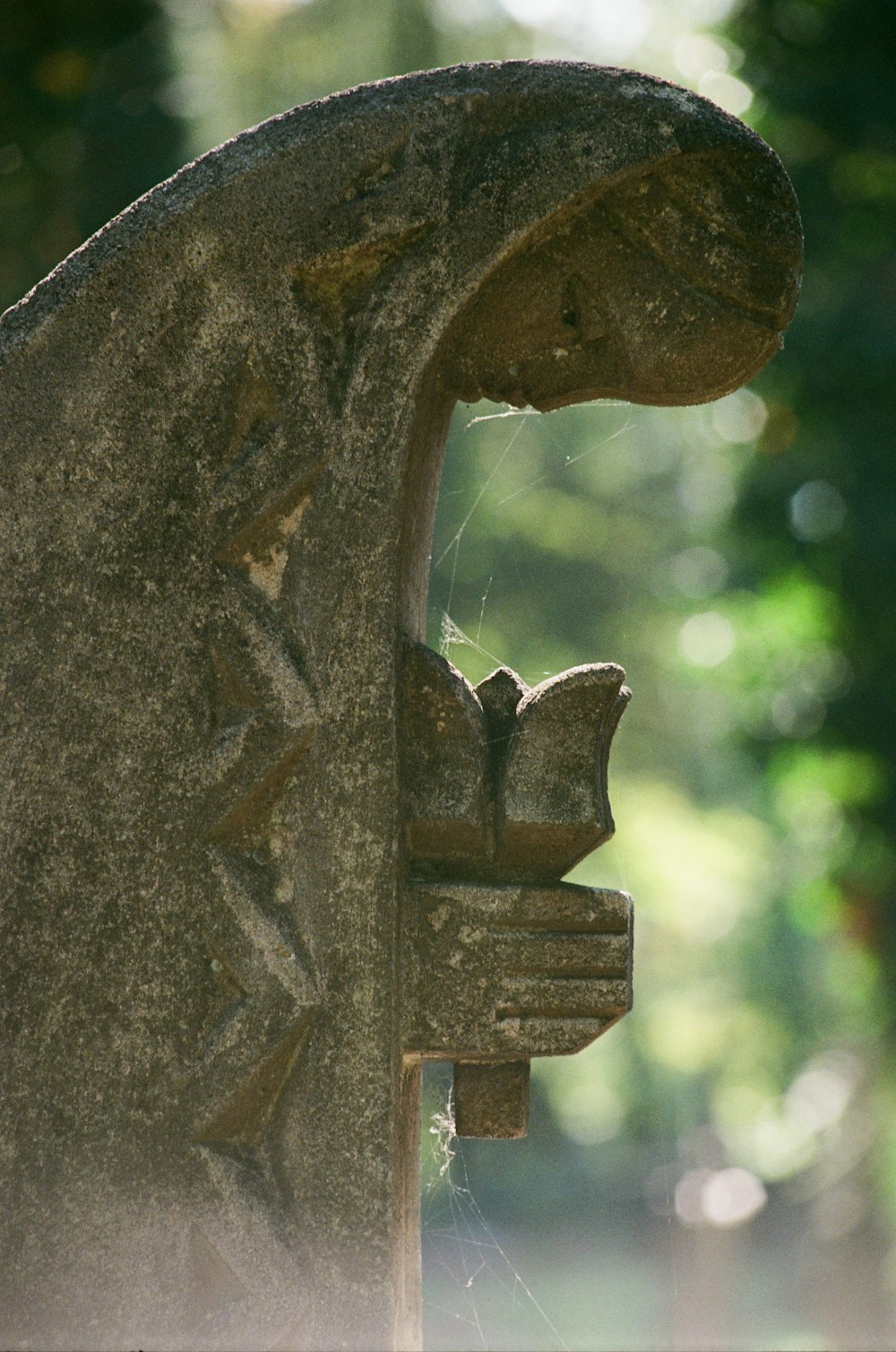 a close up of a statue with trees in the background