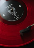 a red record player with a black disc