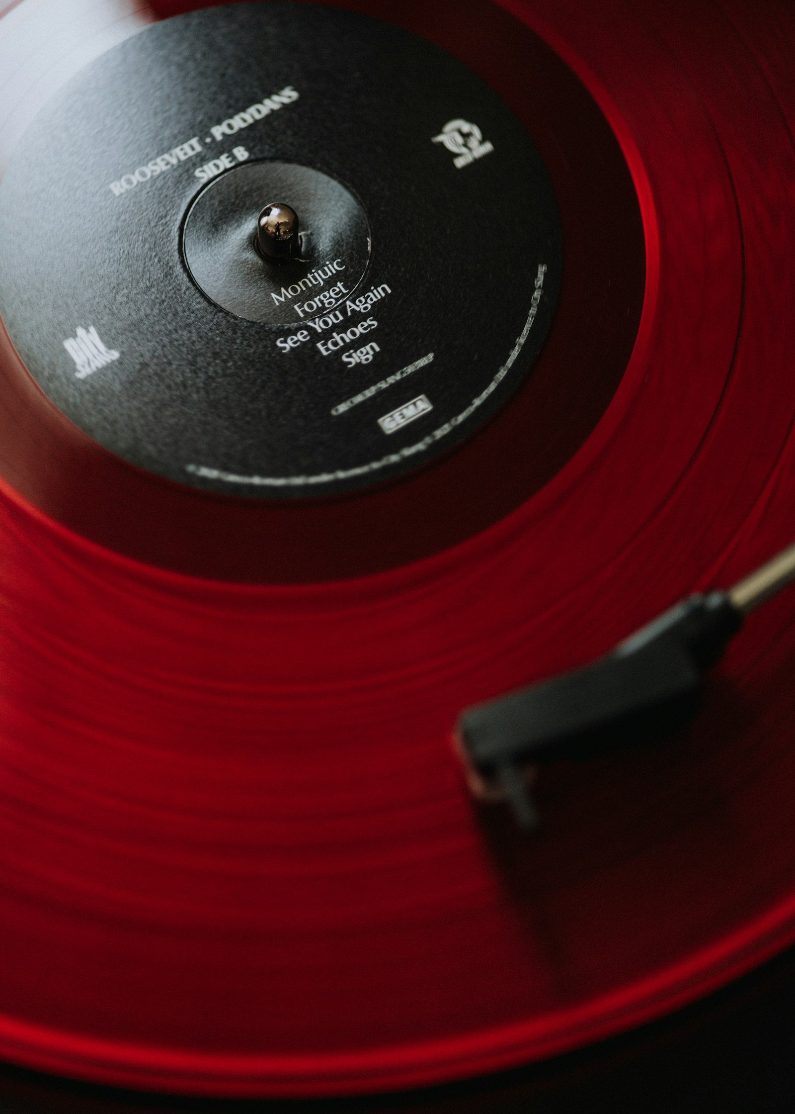 Un disque rouge sur une platine, le bras de lecture au bord
