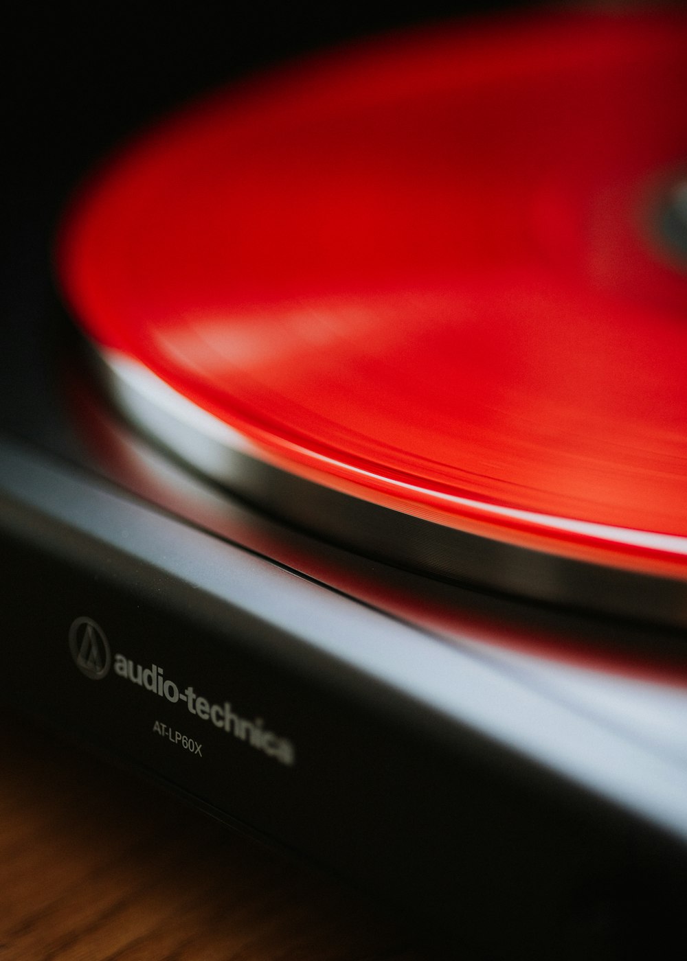 a close up of a red turntable on a wooden table