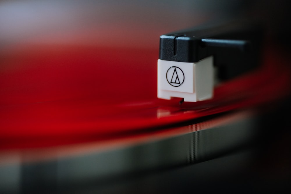 a close up of a red record with a black and white logo