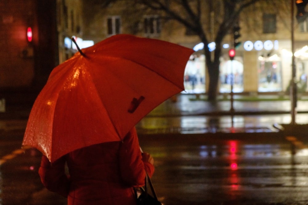 a woman walking down a street holding an umbrella