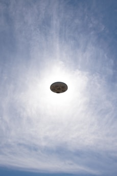 a frisbee flying through the air with a blue sky in the background