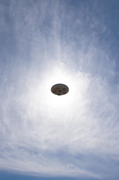 a frisbee flying through the air with a blue sky in the background