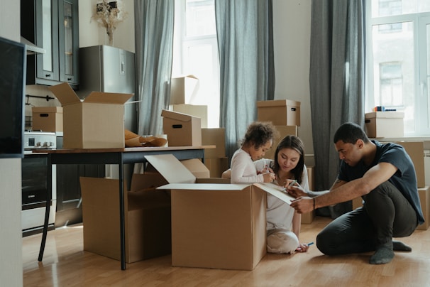 a man and a little girl are sitting on the floor in front of boxes