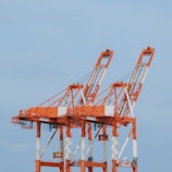 a couple of cranes that are sitting in the sky