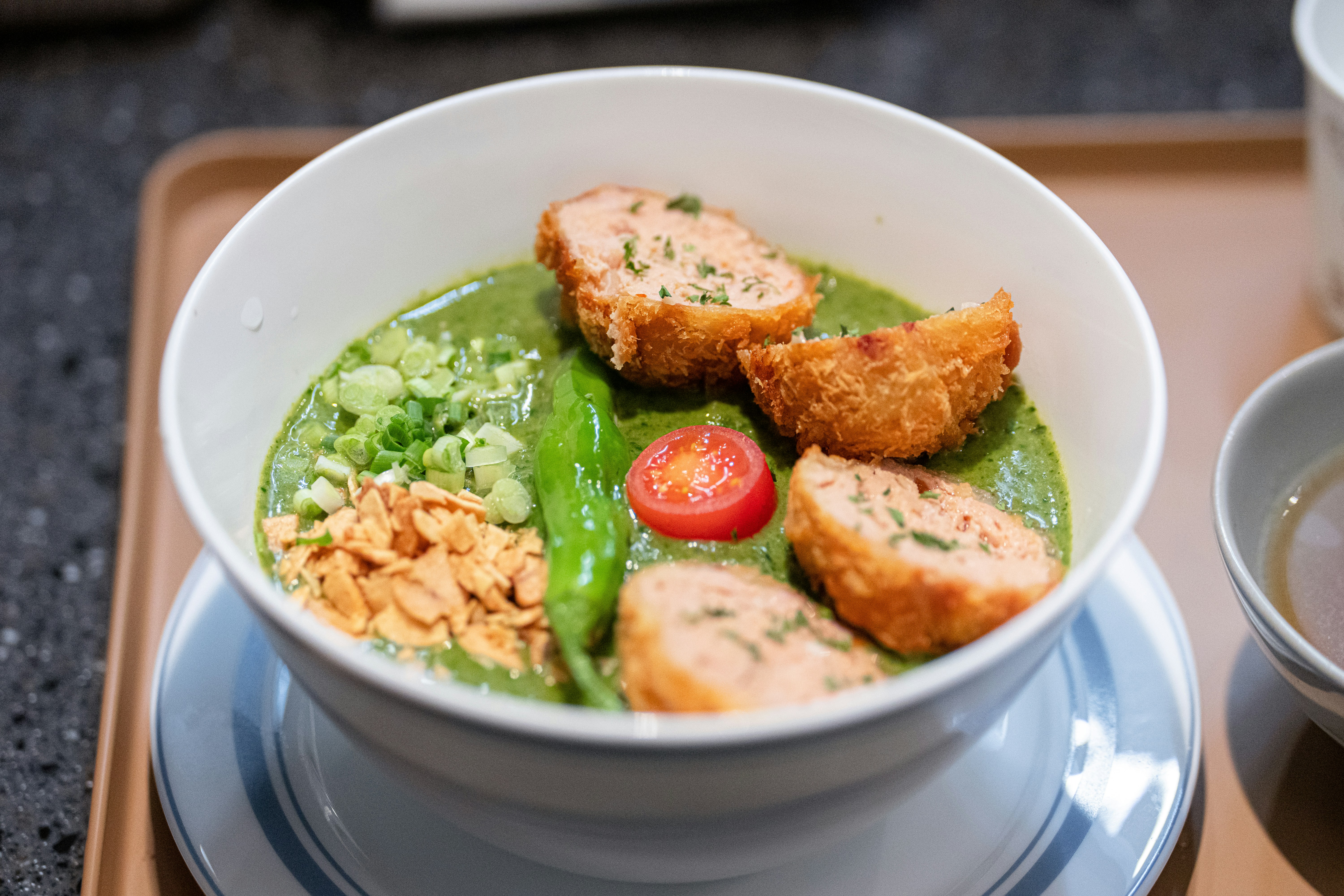 Green curry with fish cakes in a white bowl