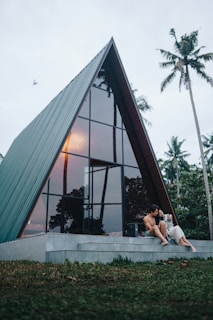 a couple of people sitting on a step next to a building