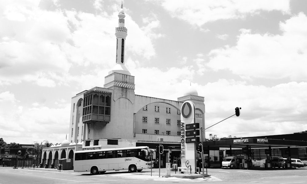 a black and white photo of a bus parked in front of a building