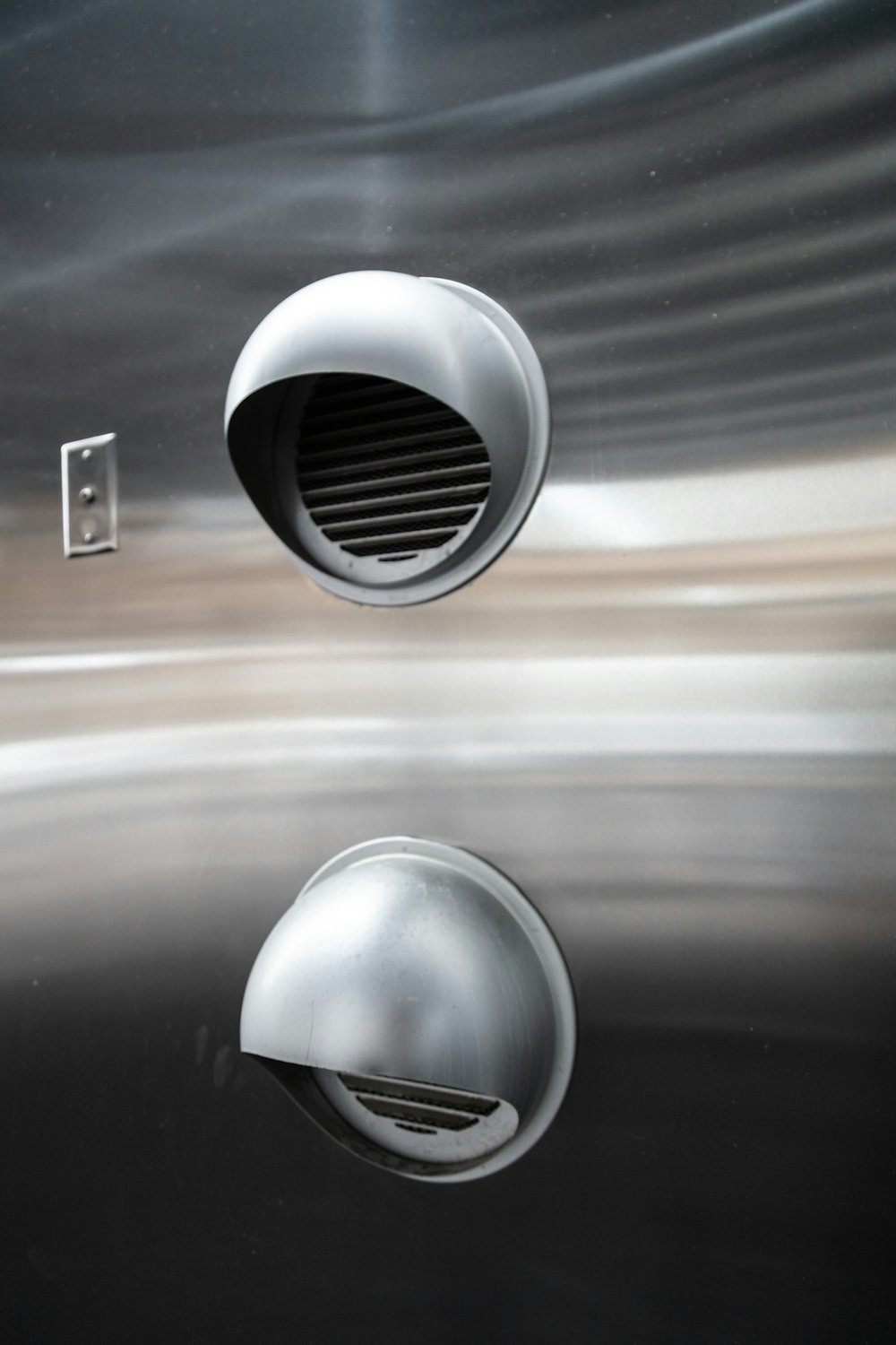 a close up of a metal object with a reflection in the water