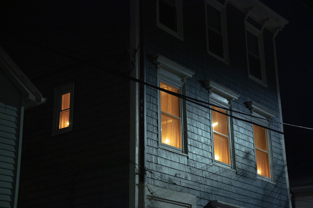 a house with two windows lit up at night