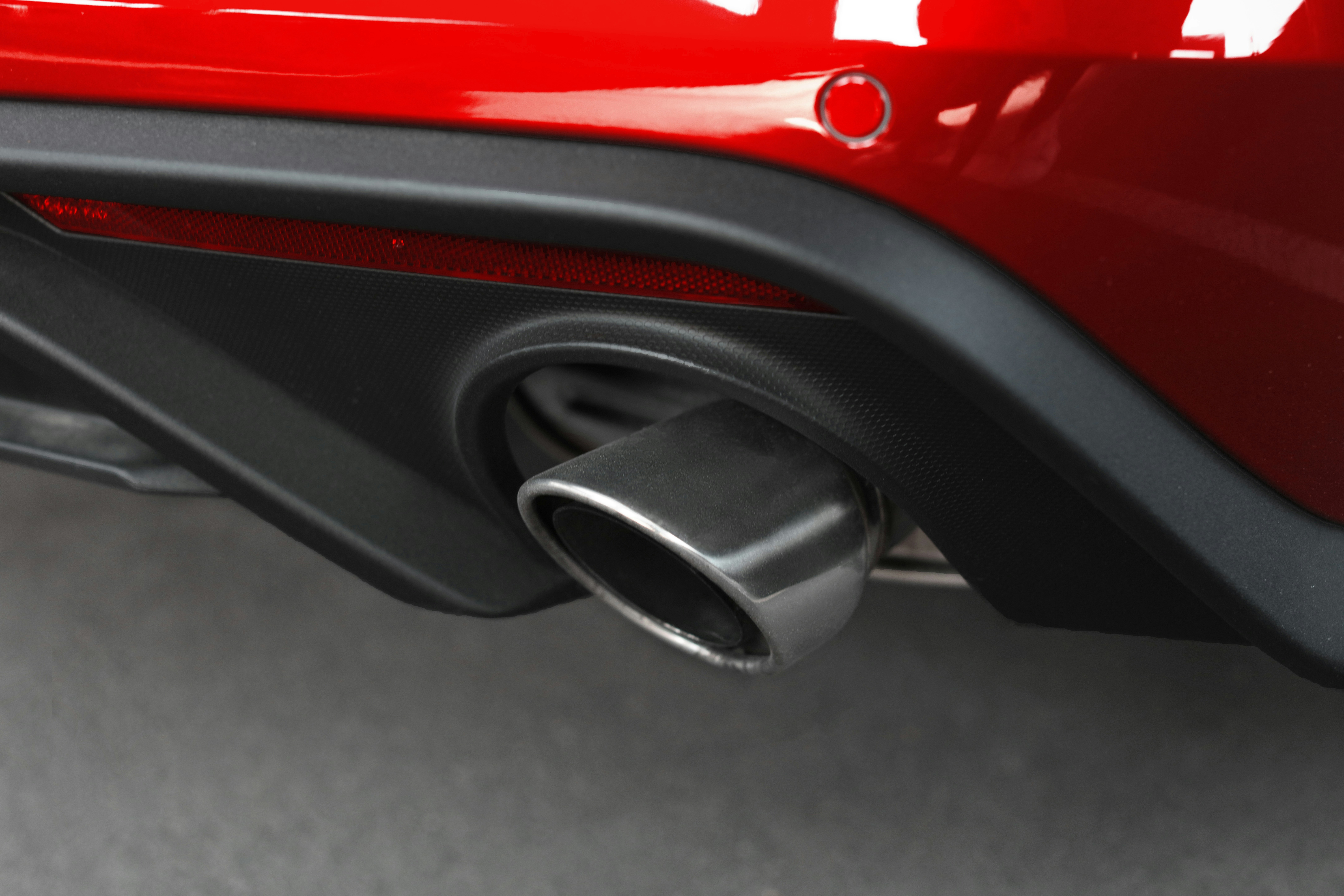 a close up of the exhaust pipe on a red car