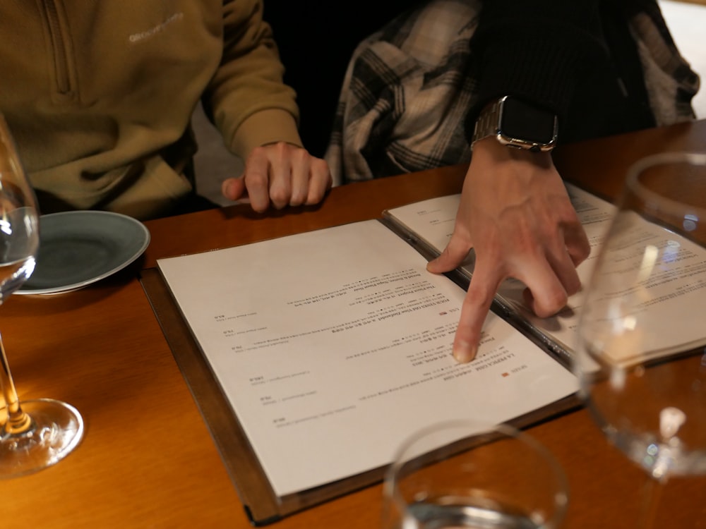 two people sitting at a table with a menu in front of them