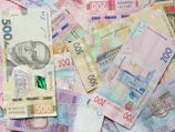 a pile of different bank notes laying on top of each other