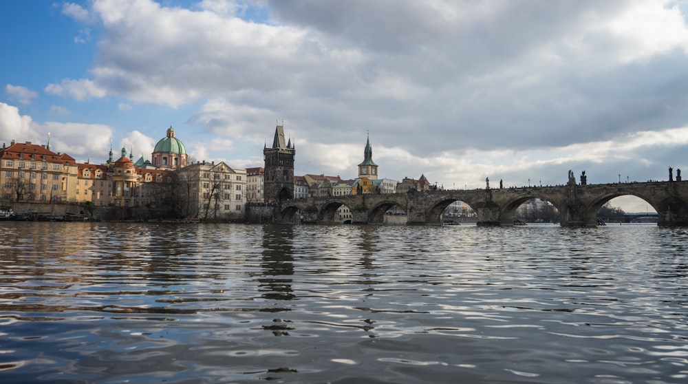 a bridge over a body of water with buildings in the background