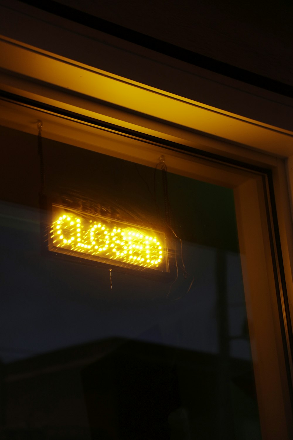 Eine Leuchtreklame mit der Aufschrift "geschlossen hängt an einem Fenster"