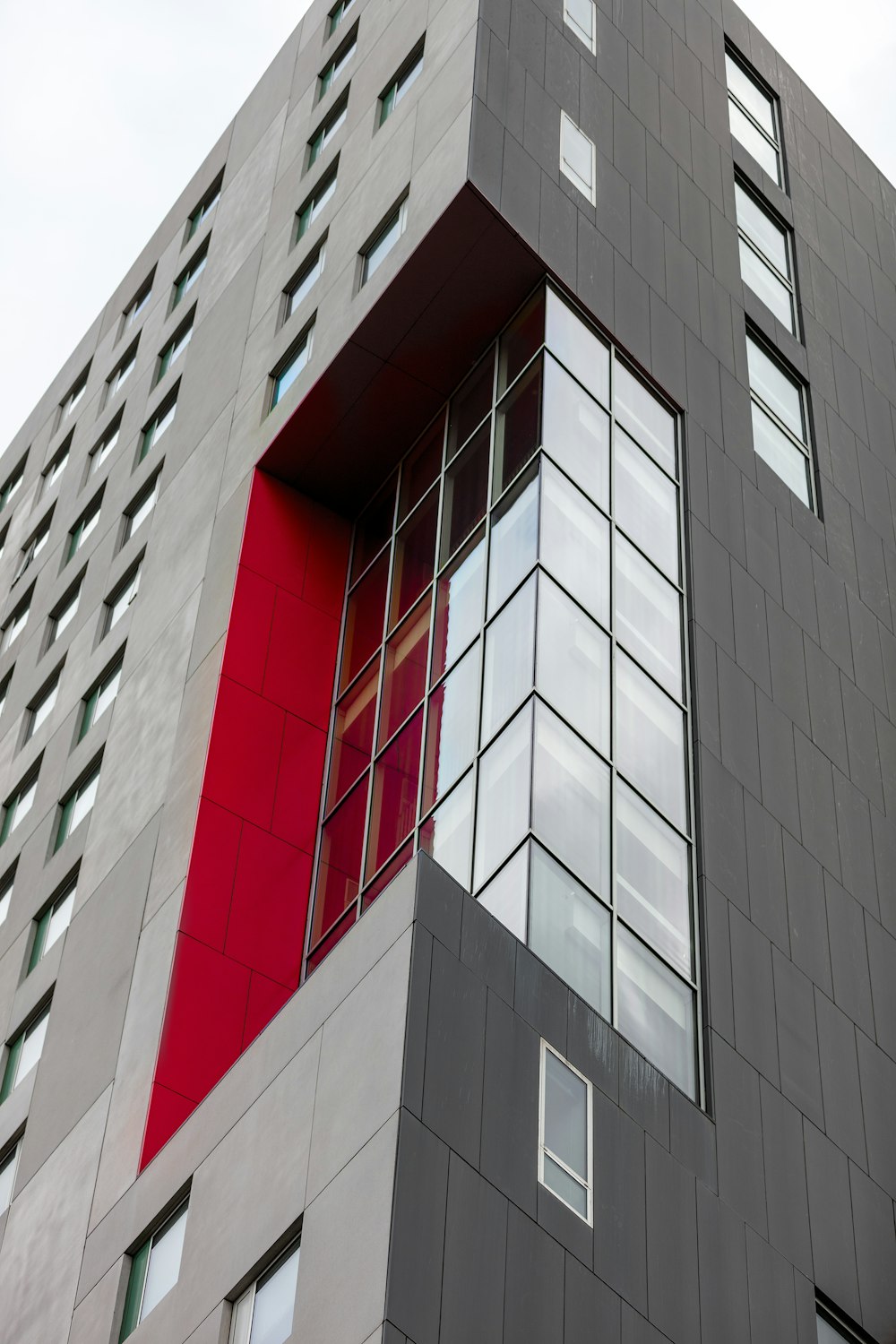 Ein hohes Gebäude mit einer roten Tür und Fenstern