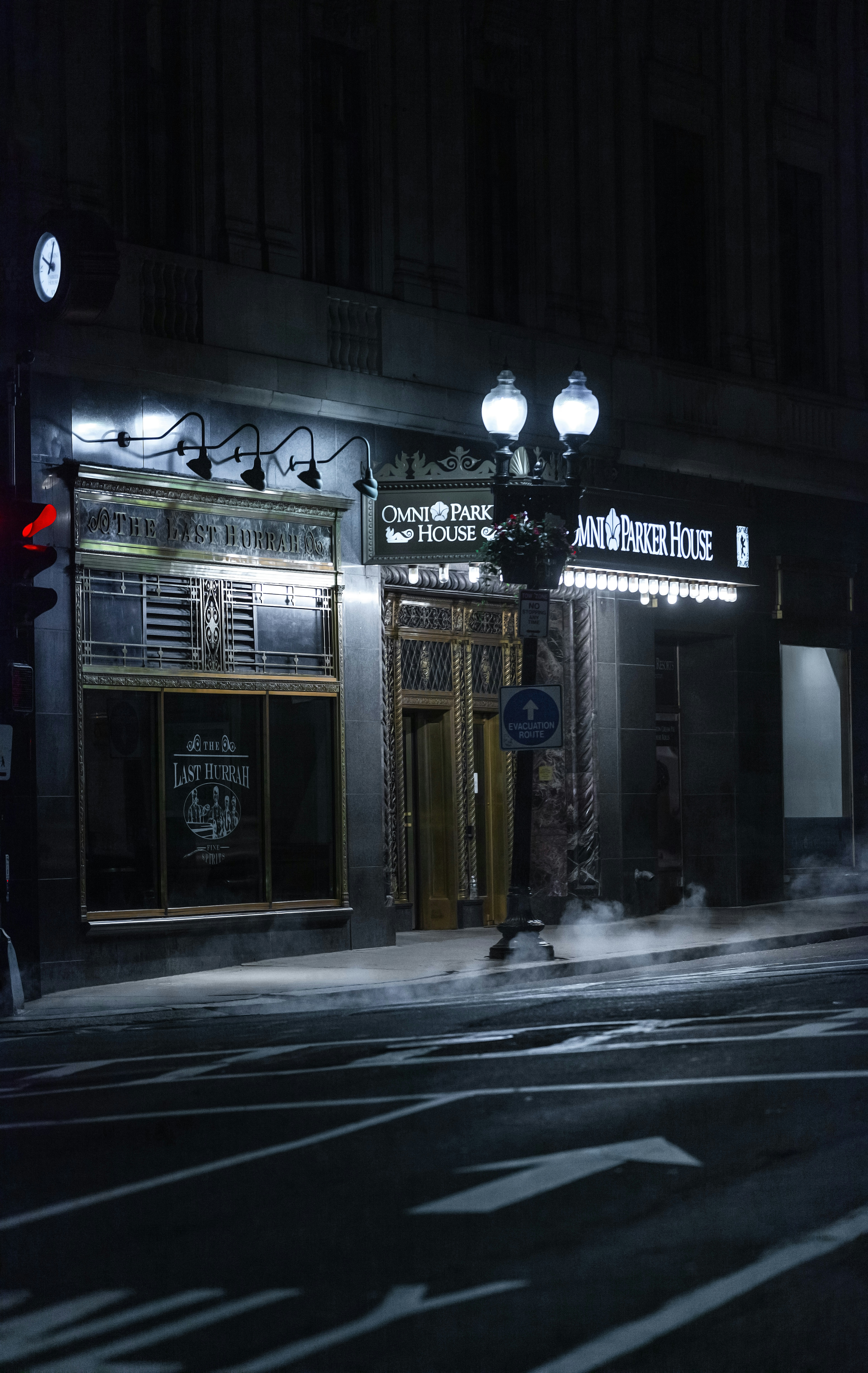 a dark street at night with a building lit up