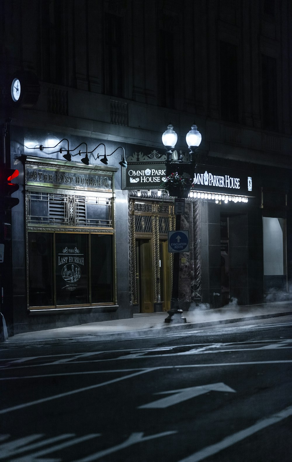 a dark street at night with a building lit up