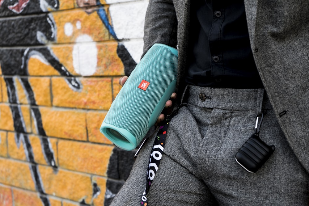 a man in a suit holding a blue speaker