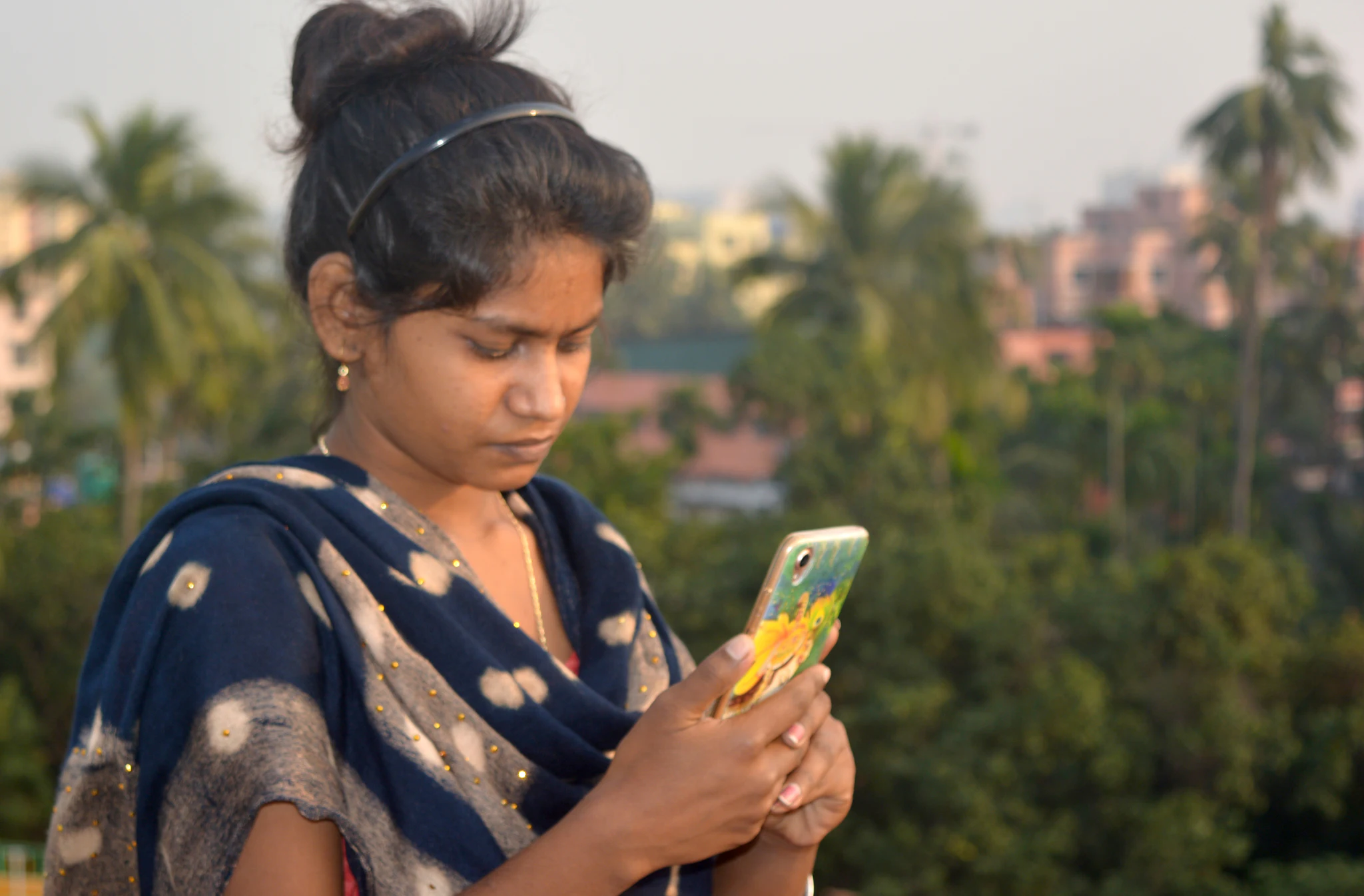 A woman reading a message on her phone outdoors