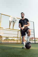 a man standing on top of a soccer ball