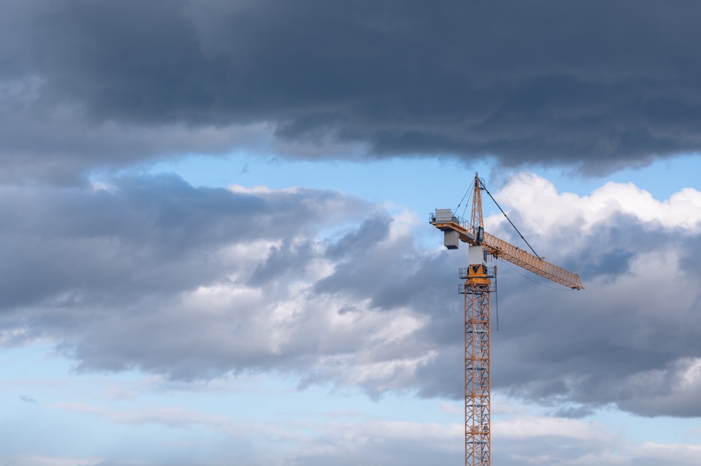 a crane is on top of a building under a cloudy sky