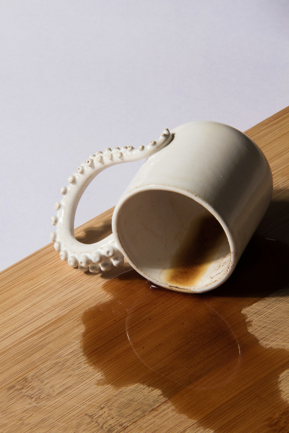 a white coffee cup sitting on top of a wooden table