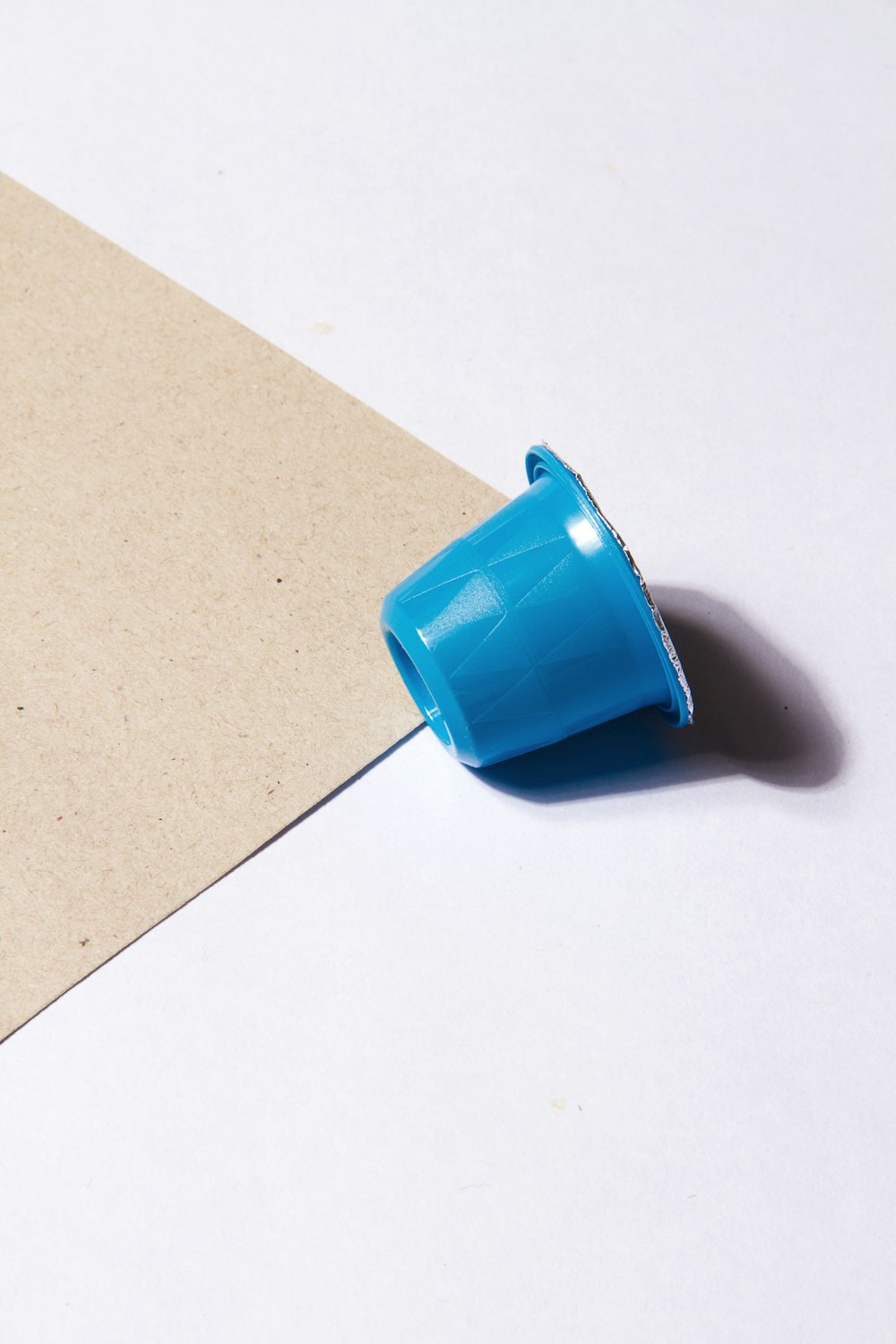 a blue cup sitting on top of a piece of paper