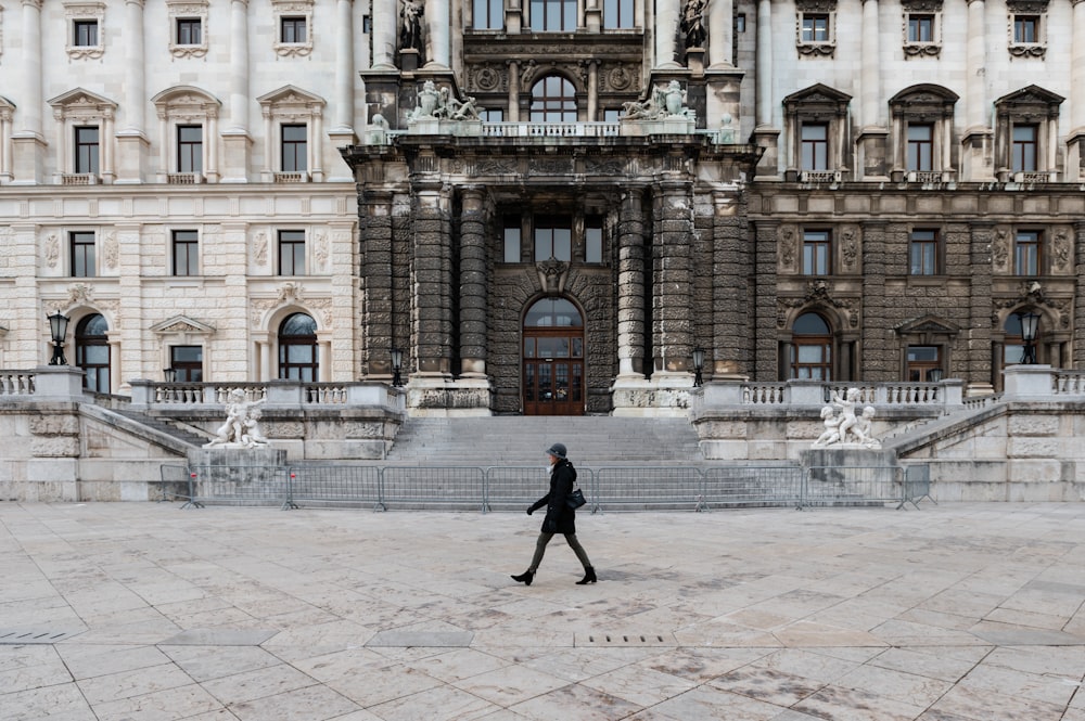 a person walking in front of a large building