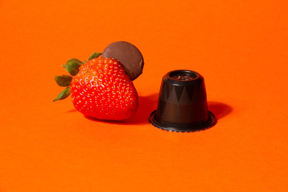 eine mit Schokolade überzogene Erdbeere neben einer mit Schokolade überzogenen Erdbeere