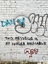 a brick wall with graffiti written on it