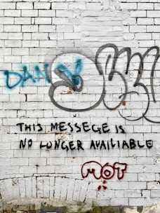 a brick wall with graffiti written on it