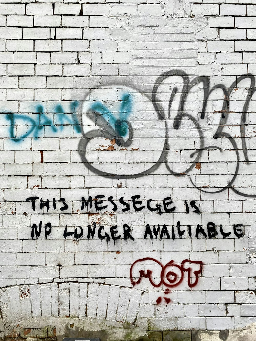 a brick wall with graffiti written on it