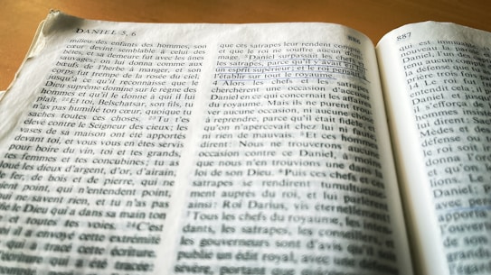 A book opened to a page with numbered paragraphs and headings, written in French. The text appears to be from a religious or philosophical work, and a section is underlined with a blue pen.